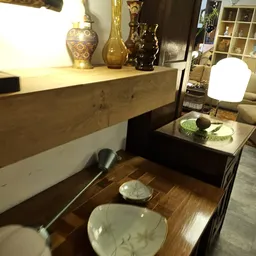 Woonkamerinrichting met houten meubels, decoratieve objecten en verlichting in een kringloopwinkel