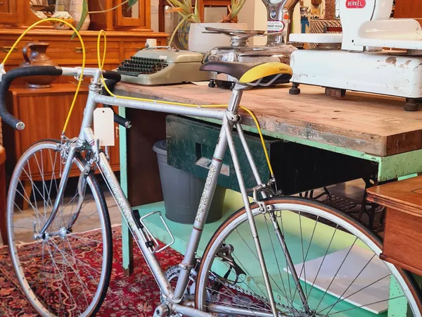 Werkruimte met fietsen, houten tafel en diverse kringloopwaar op de achtergrond