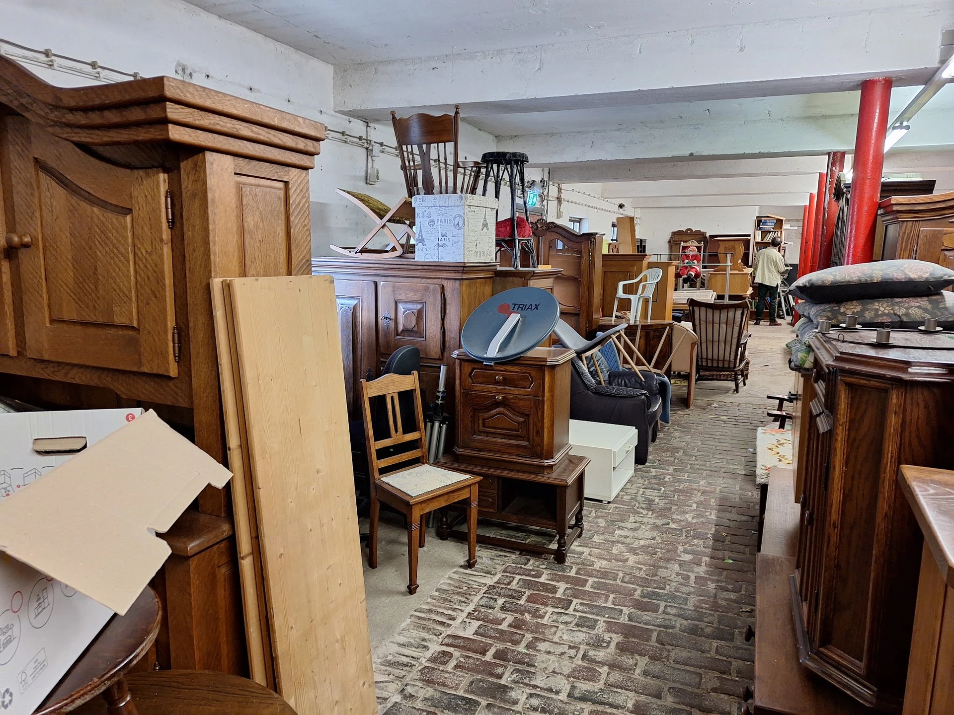 Ruim opgezet interieur van tweedehands winkel met houten meubels, kasten, stoelen en diverse huishoudartikelen