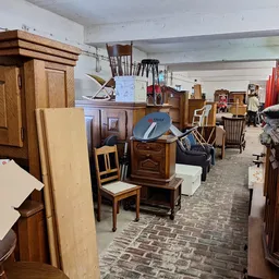Ruim opgezet interieur van tweedehands winkel met houten meubels, kasten, stoelen en diverse huishoudartikelen