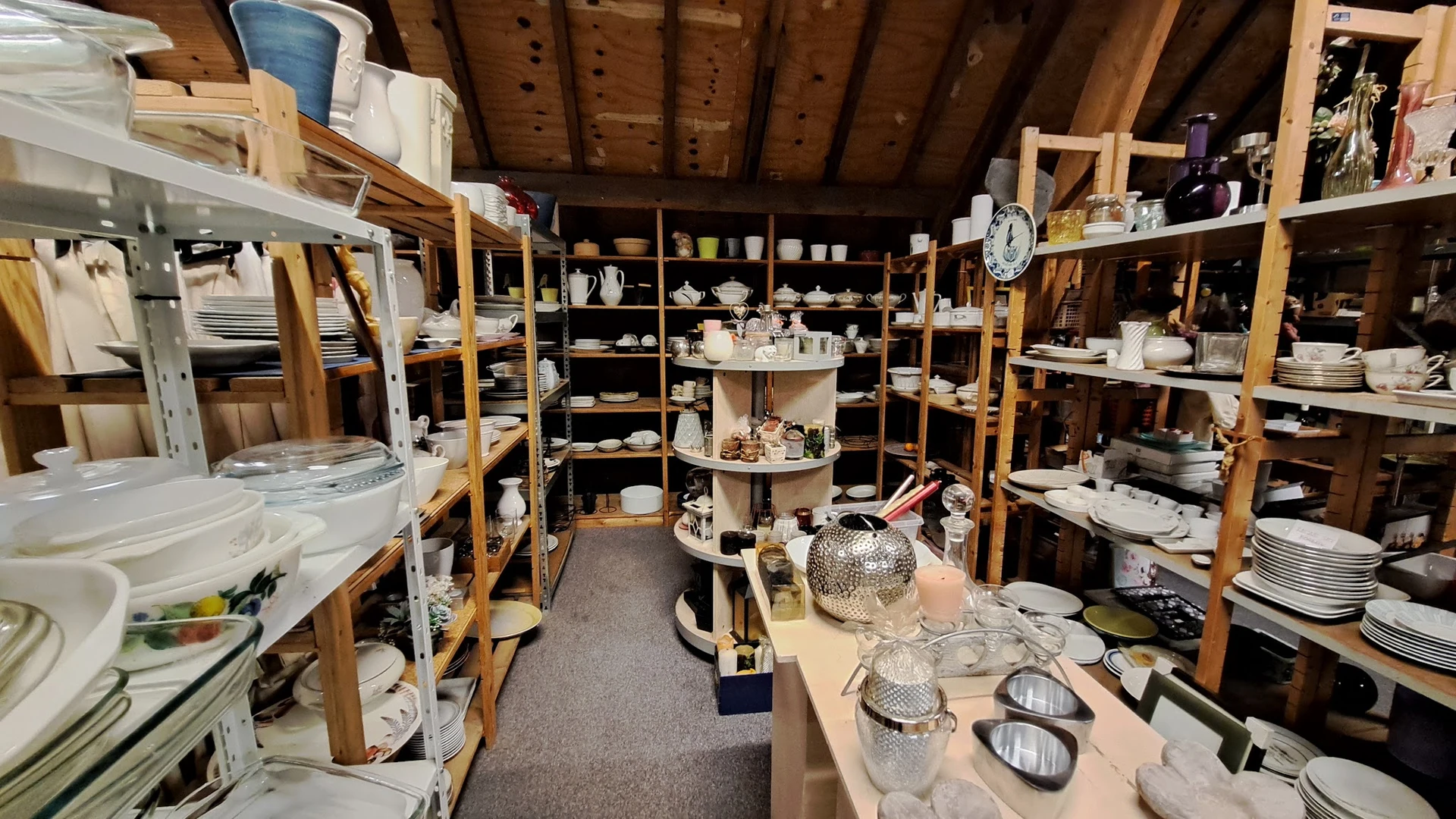 Overzicht van de winkelvloer met stellingen vol huishoudelijke artikelen, servies en decoratieve spullen