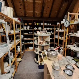 Overzicht van de winkelvloer met stellingen vol huishoudelijke artikelen, servies en decoratieve spullen