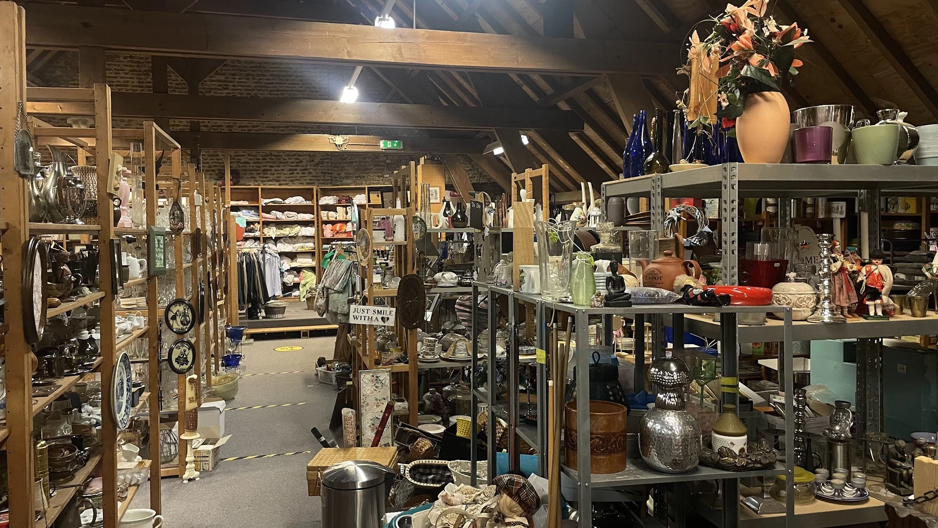 Winkelvloer met stellingen vol huishoudelijke artikelen, servies en decoratie