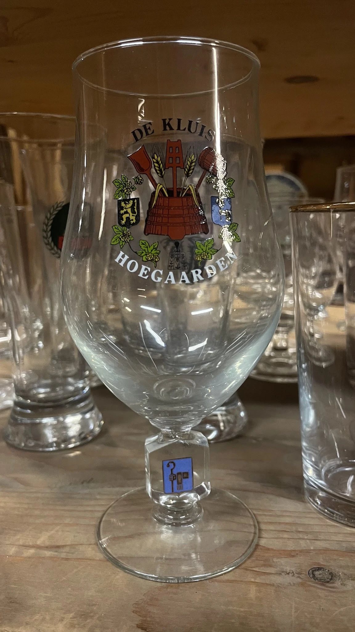 Glazen bierpullen met logo 'Hoegaarden' opgesteld op een tafel