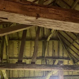 Houten zolderconstructie met balken en zinken platen onder dak