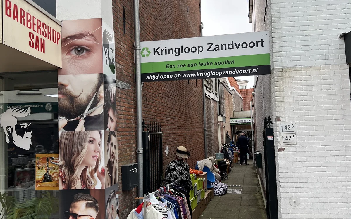 Winkelgevel van Kringloop Zandvoort met etalage en groene winkelscherm aan een straatje