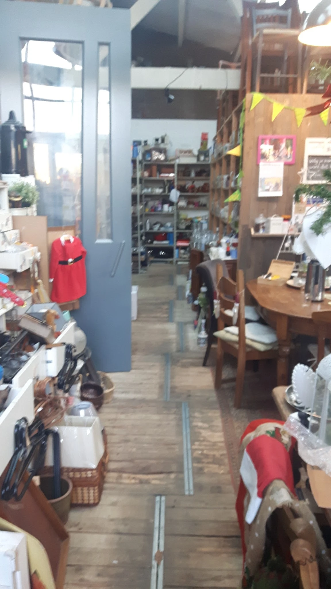 Winkelinterieur met stellingen, meubels en diverse artikelen langs de wanden en in het middendeel