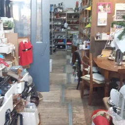 Winkelinterieur met stellingen, meubels en diverse artikelen langs de wanden en in het middendeel