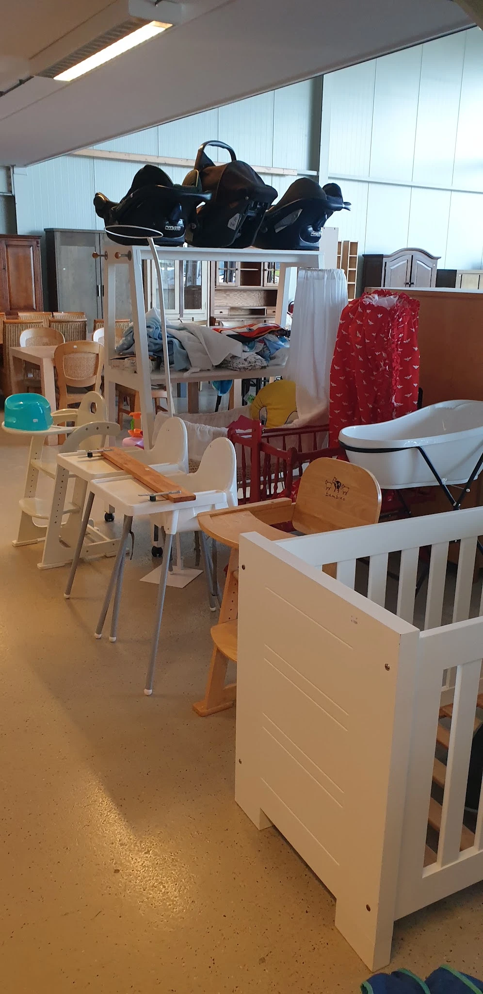 Babymeubilair en babyuitzet in de winkel: hoogstoel, babybadkuip, wieg en houten speelgoedstukken