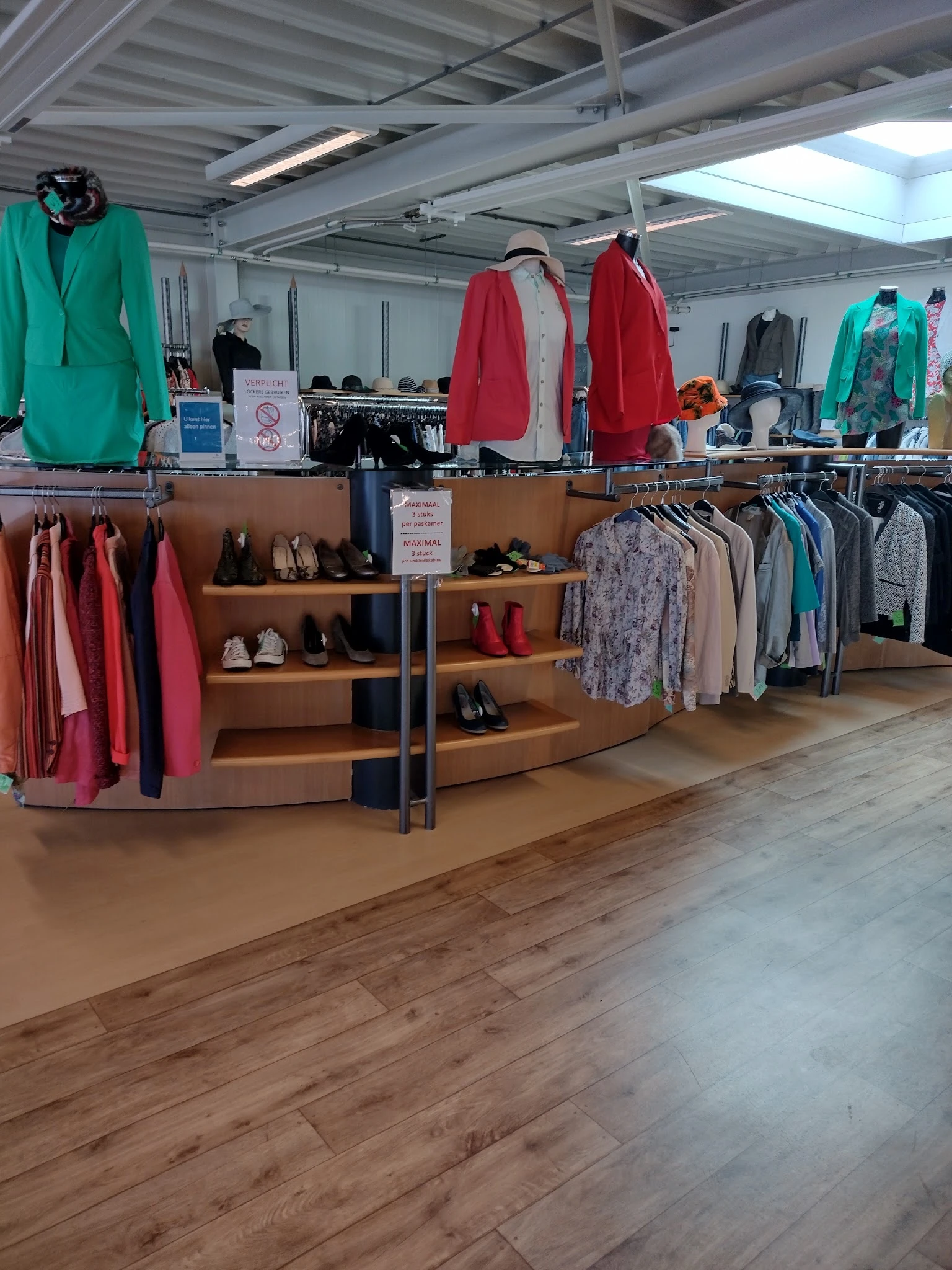 Tweedehands kleding en schoenen op rekken en stellingen in de kringloopwinkel