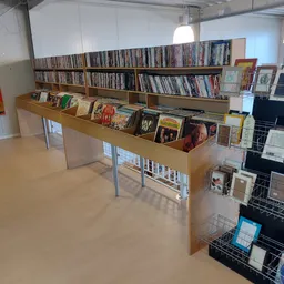 Houten display met dvd's, cd's en boeken uitgestald in de kringloopwinkel