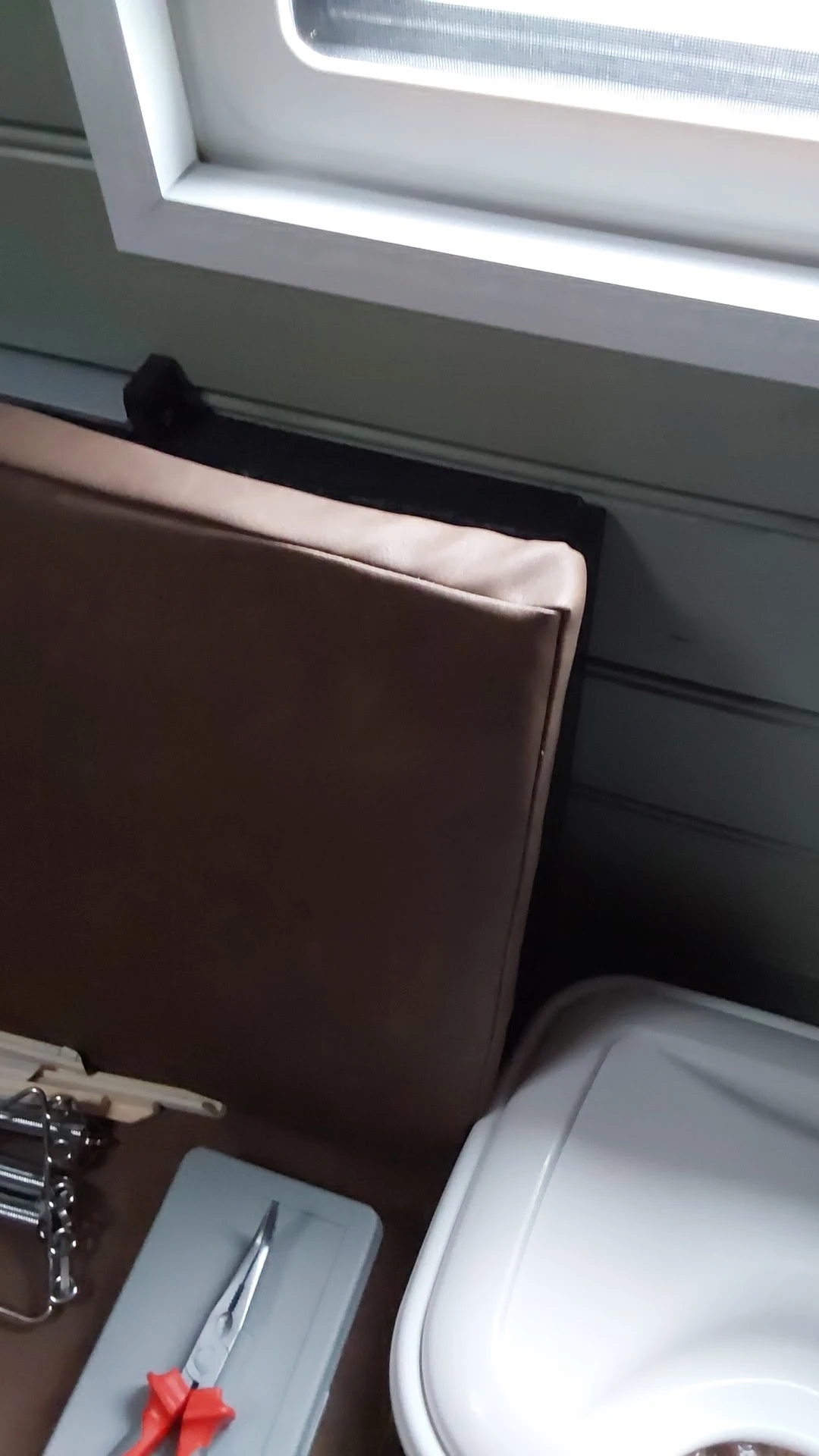 Close-up van een bruin leren meubelstuk met witte rand, mogelijk een bank of stoel