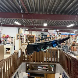Overzicht van de winkelvloer met diverse artikelen, meubels en stellingen in een ruime kringloopwinkel