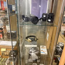 Glasvitrine met fotocamera's en lenzen op twee schappen