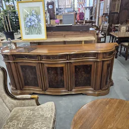 Houten dressoir met drie deuren en laden in klassieke stijl, in een kringloopwinkel
