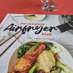 Opengeslagen kookboek 'het complete Aardappelen boek' met afbeelding van een gerecht met noodles en groenten op een bord