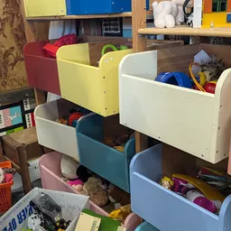 Gestapelde gekleurde opbergboxen met speelgoed, boeken en diverse huishoudartikelen