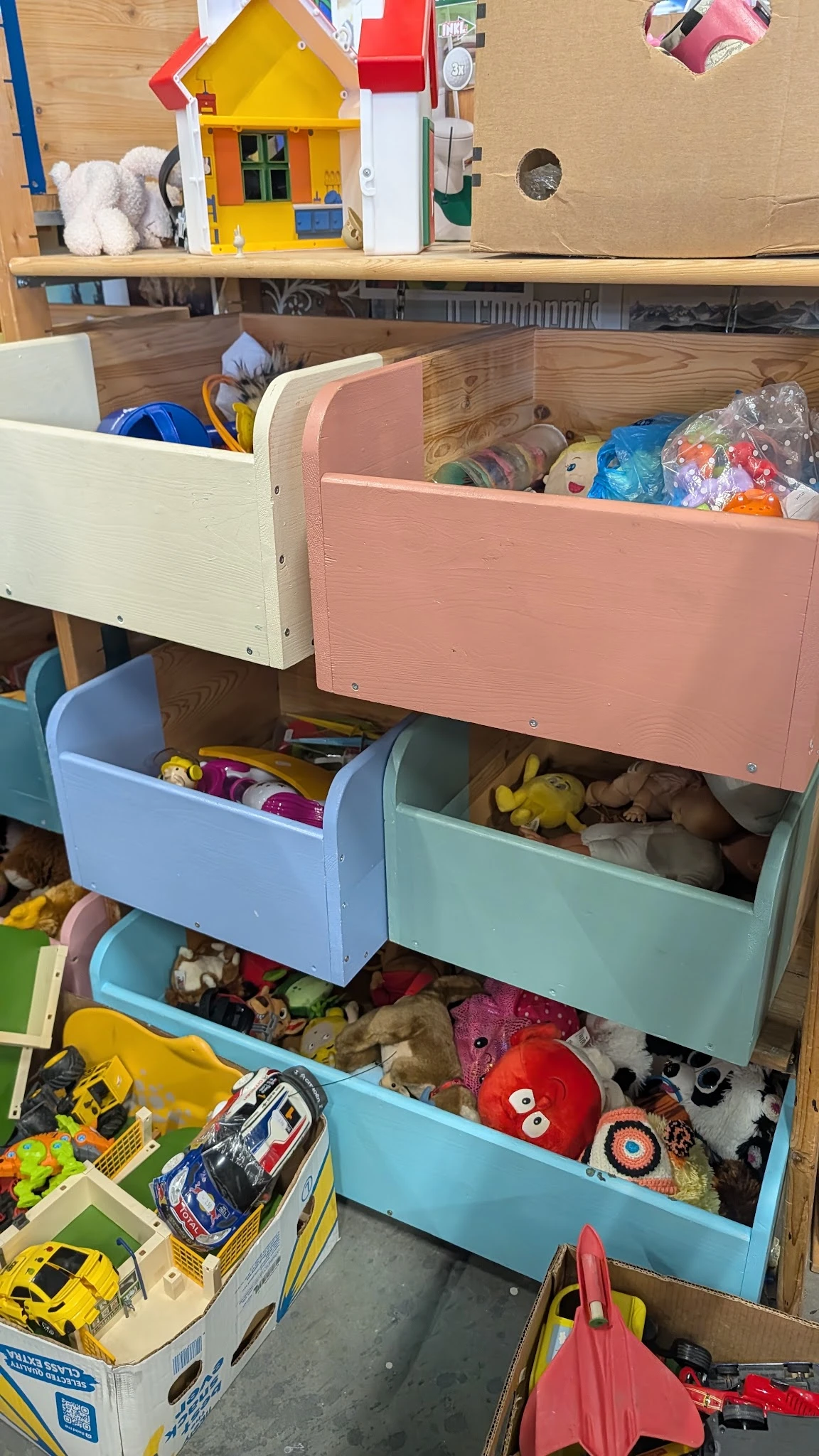 Gekleurde opbergboxen met speelgoed en knuffels in verschillende laden