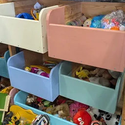 Gekleurde opbergboxen met speelgoed en knuffels in verschillende laden
