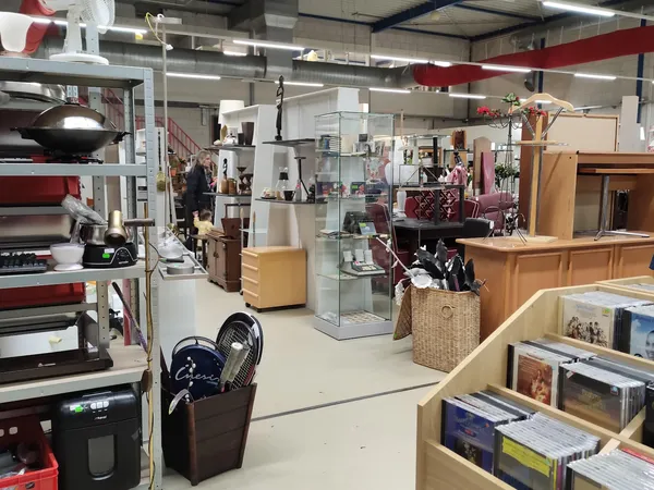 Overzicht van de winkelruimte met stellingen, displays, meubels en diverse tweedehandsartikelen