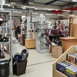Overzicht van de winkelruimte met stellingen, displays, meubels en diverse tweedehandsartikelen