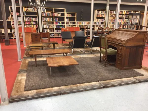 Interieur van kringloopwinkel met vintage meubels, boeken in kastjes, rode vloer en grijs tapijt