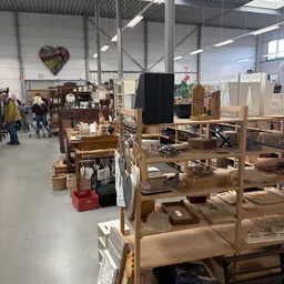 Winkelvloer met houten meubels, rekken enDisplayItems in een groot licht magazijnachtig interieur