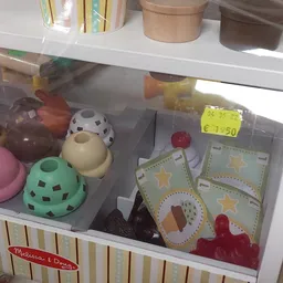 Speelgoedkast met onder meer roze en groene voedersilos, een witte vogel, speelgoedkaarten en rode blokjes.