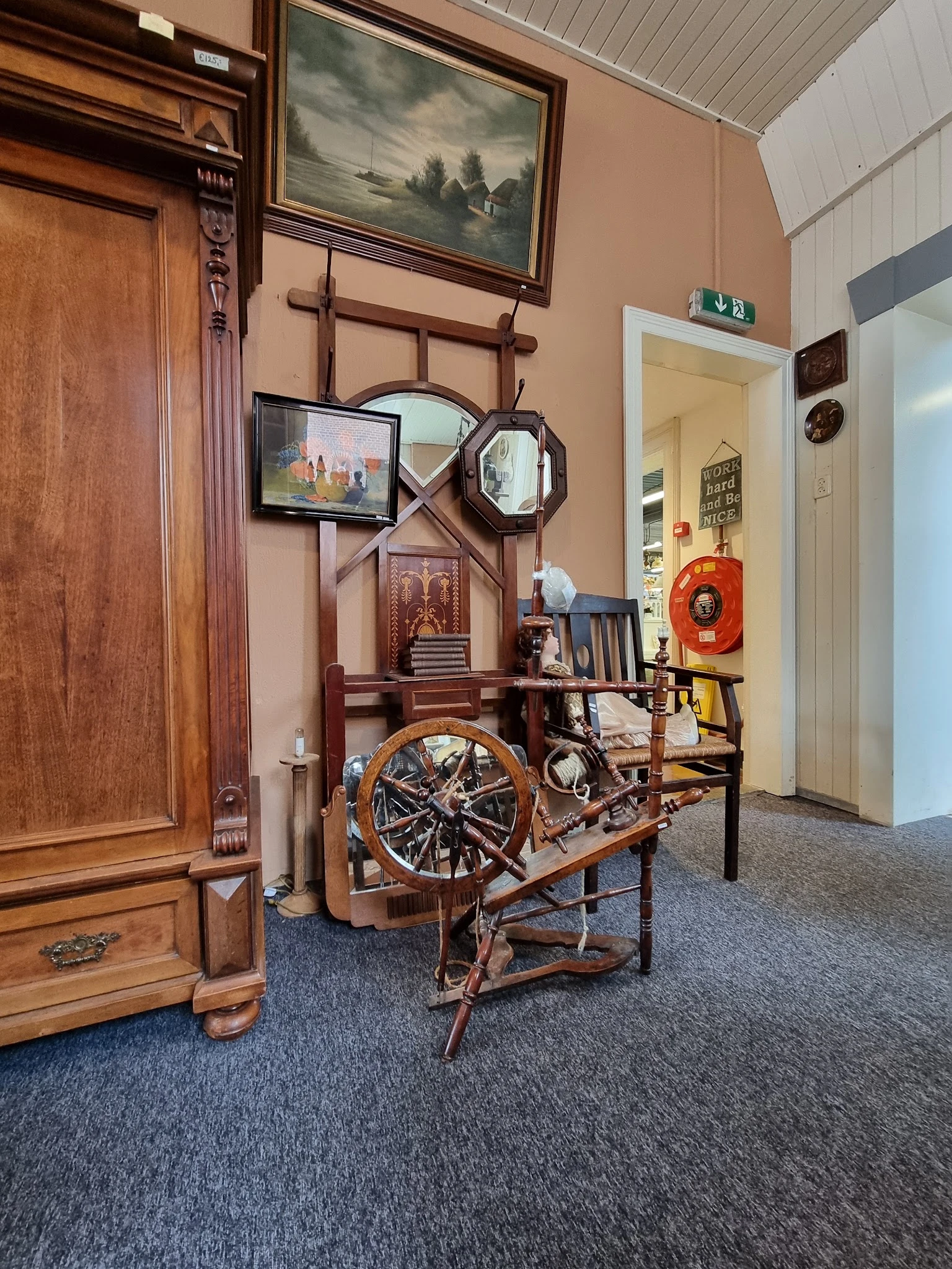 Winkelvloer met diverse tweedehands meubels en decoratie-items, inclusief een fiets, houten deuren en spiegels