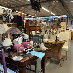 Winkelvloer met uitgestalde meubels, lampen en huishoudartikelen in een ruim magazijn