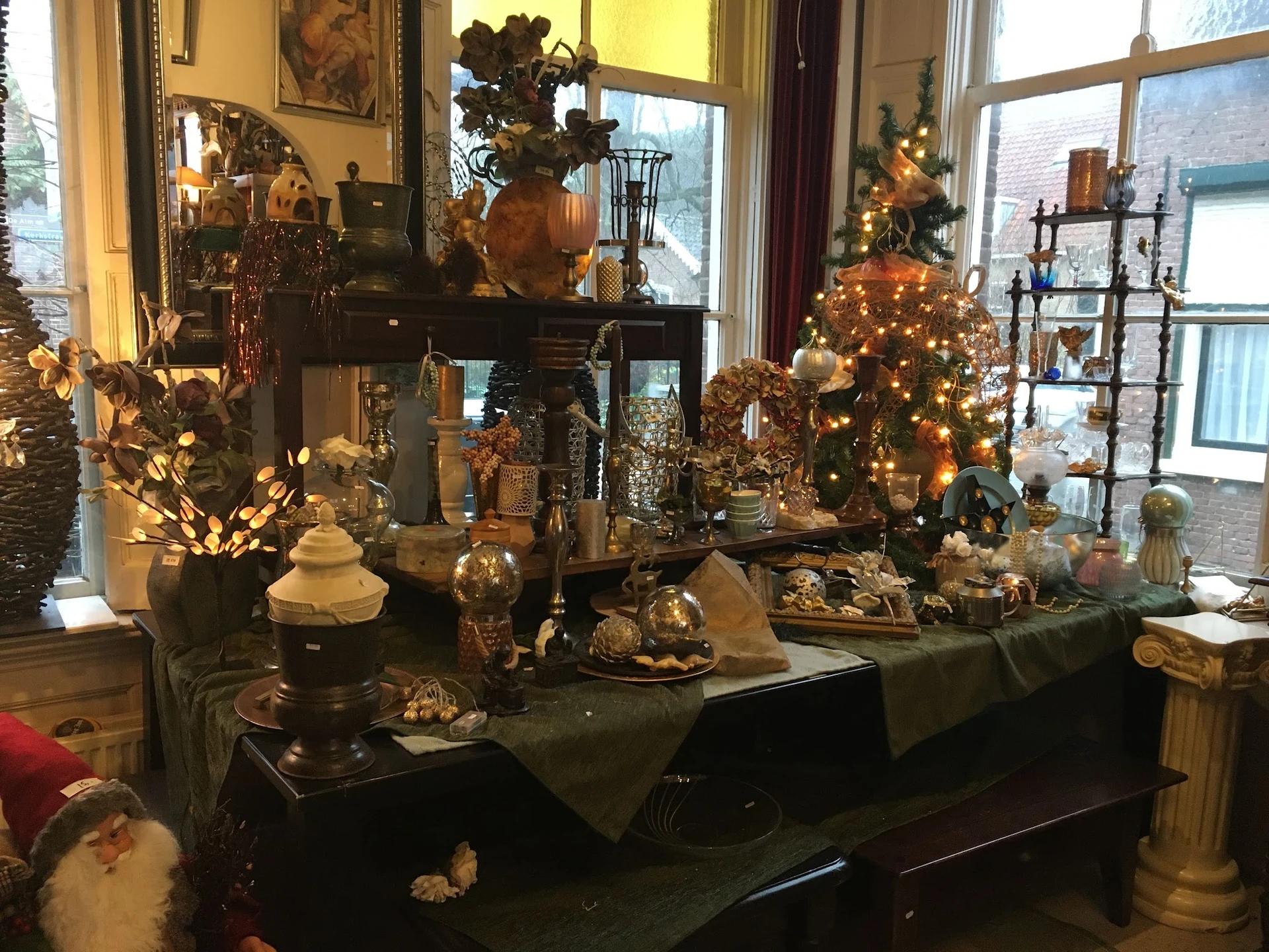 Winkelinterieur met kerstversiering en decoratieve spullen op tafels en in de etalage