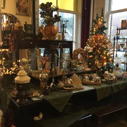 Winkelinterieur met kerstversiering en decoratieve spullen op tafels en in de etalage