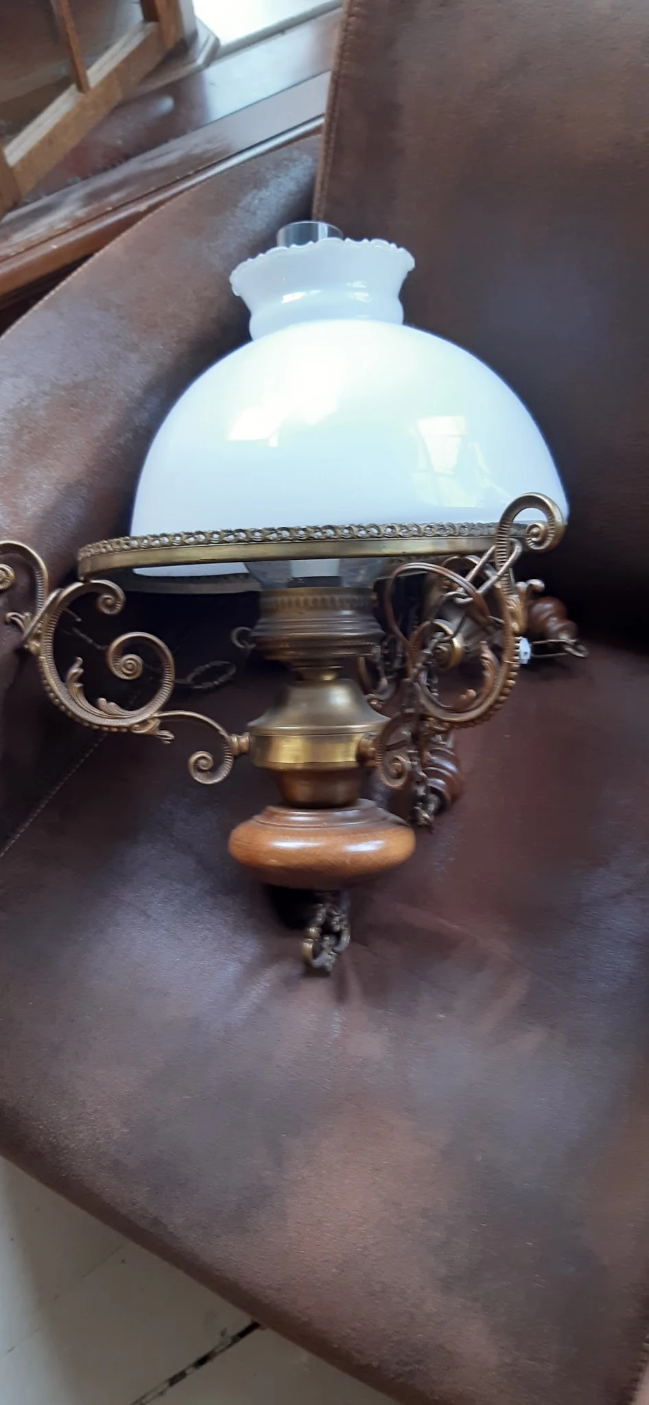 Decoratieve bronzen schaal met ornamentale handvatten en houten voet, close-up.