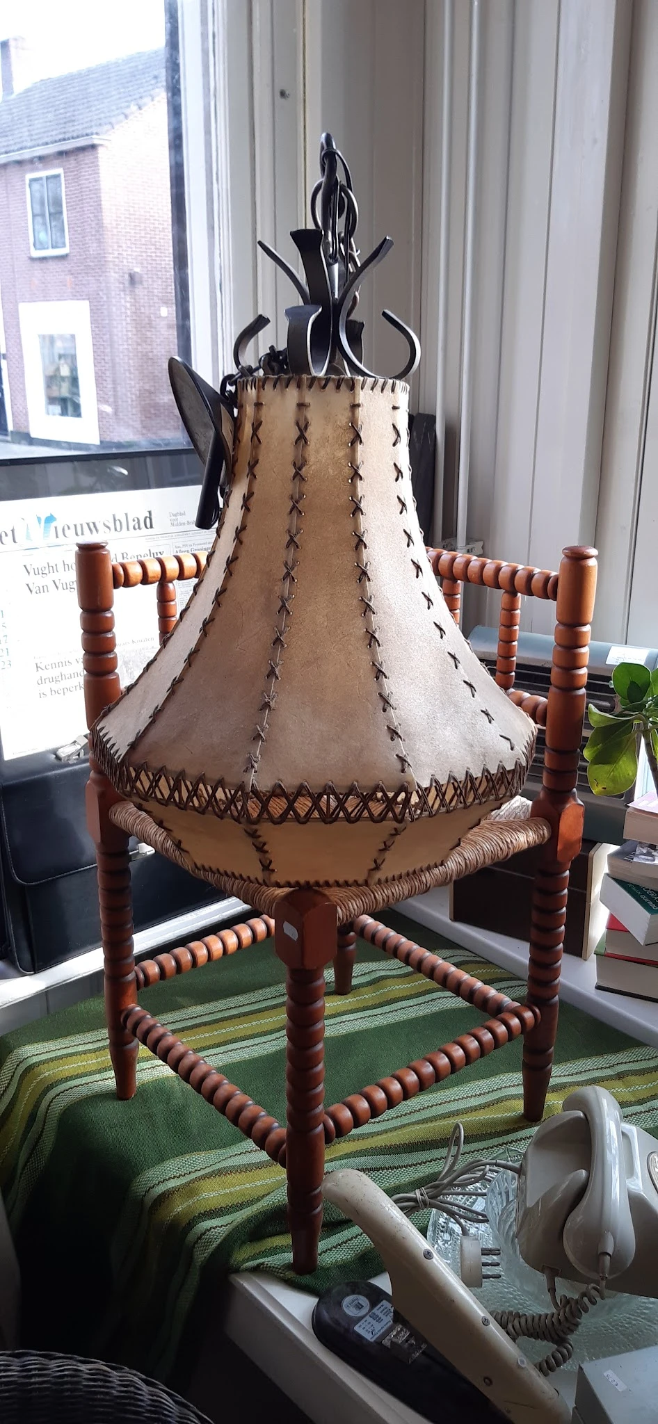 Handgemaakte lampenkapvorm van leer met decoratieve stikwerk en houten frame