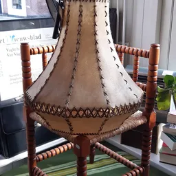 Handgemaakte lampenkapvorm van leer met decoratieve stikwerk en houten frame