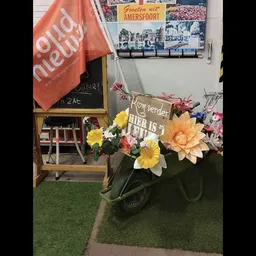 Decoratieve fietstas versierd met kunstbloemen in gele, roze en oranje tinten