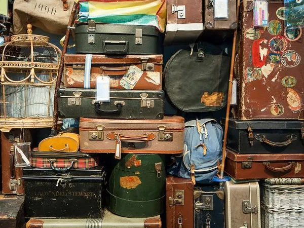 Verzameling vintage koffers en tassen gestapeld in de winkel