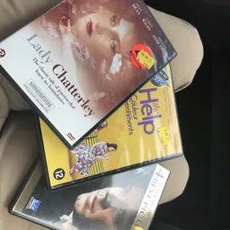 Stapel dvd's en boeken op een tafel, waaronder 'Lady Chatterley' en 'The Help'