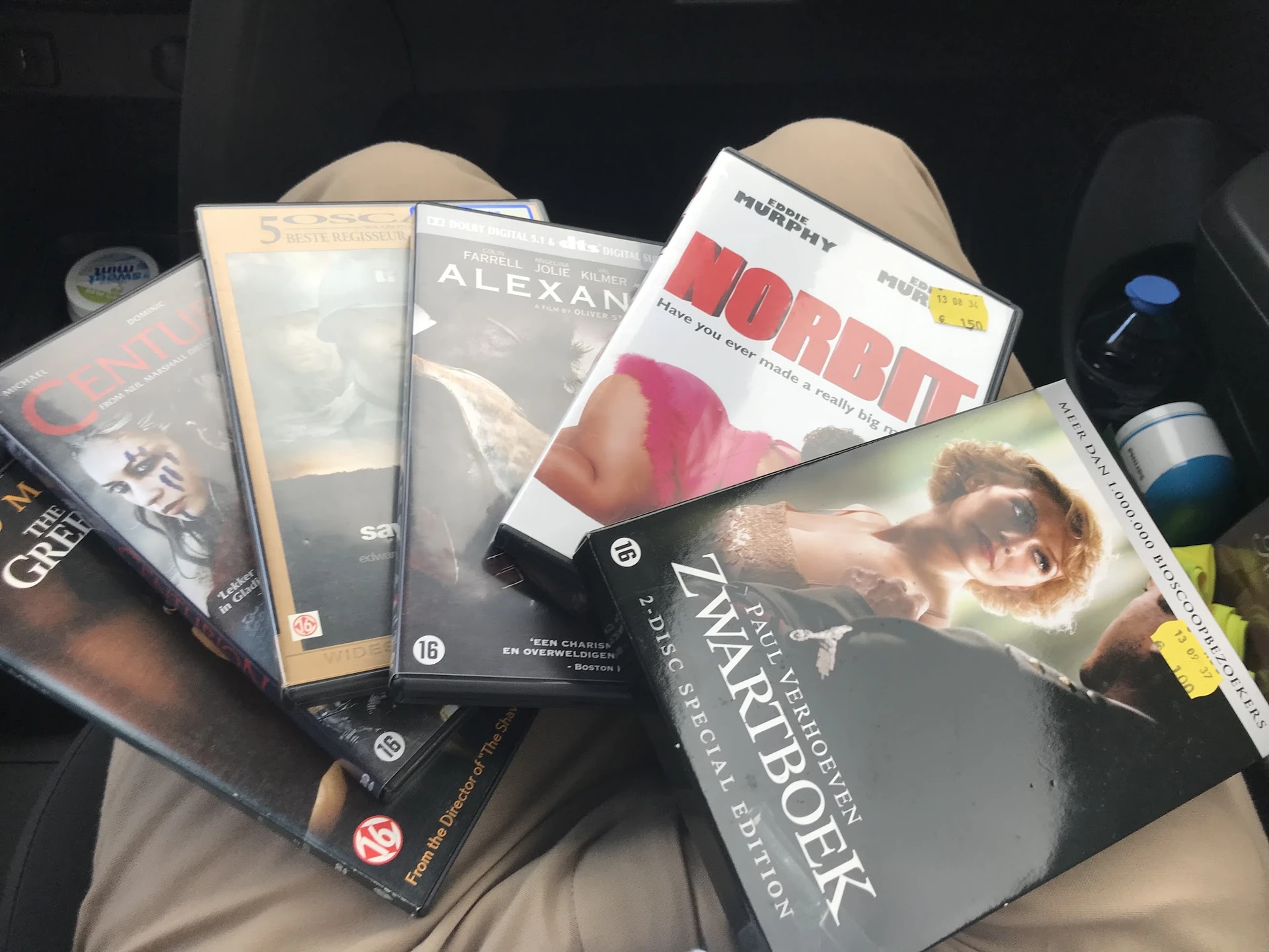 Verzameling dvd's en blu-rays in een doos, waaronder films als 'Alexander', 'Forrest Gump' en 'Warcraft'