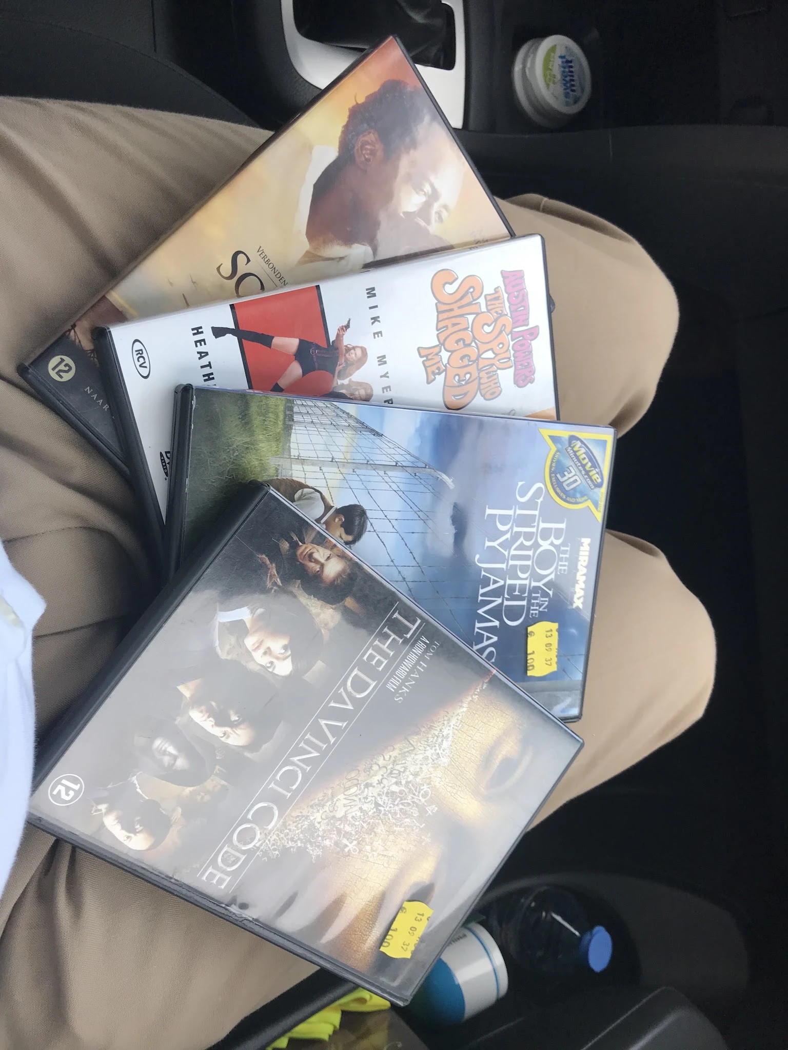 Stapel dvd's en blu-ray films op een stoel, waaronder titels zoals Game of Thrones en Scary Movie