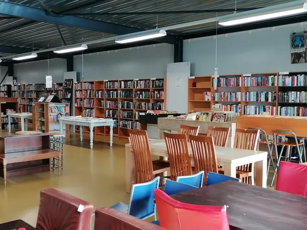 Leeszaal met boekenkasten, tafels en stoelen in een kringloopwinkel