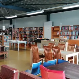 Leeszaal met boekenkasten, tafels en stoelen in een kringloopwinkel