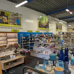Winkelvloer met stellingen vol decoratieartikelen, glazen, vazen en huishoudartikel in verschillende kleuren