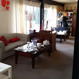 Woonkamer-achtig interieur met gestreepte bank, houten salontafel en boekenkasten in de winkel
