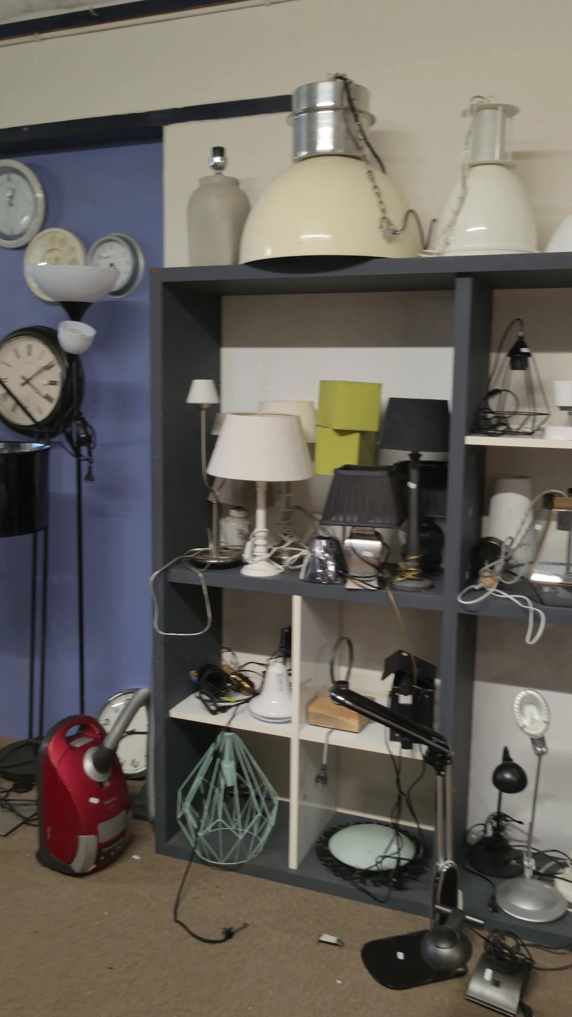 Stellingkast met diverse lampen en huishoudelijke artikelen in verschillende kleuren en stijlen