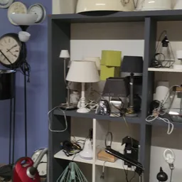 Stellingkast met diverse lampen en huishoudelijke artikelen in verschillende kleuren en stijlen