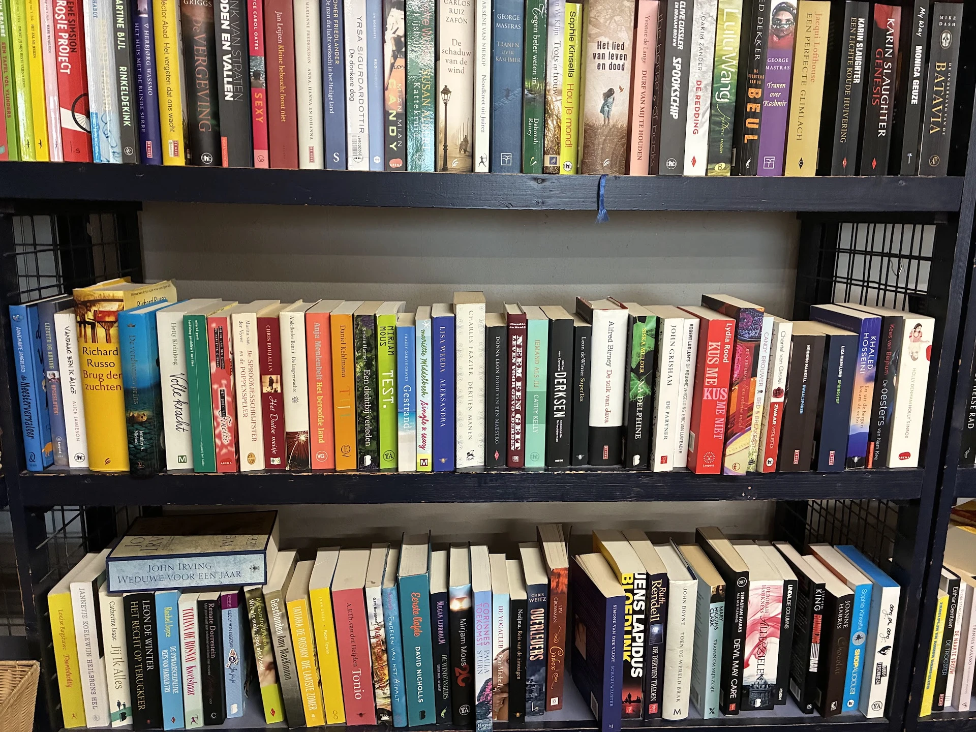 Boekenkasten met uitgestalde tweedehands boeken in verschillende formaten en kleuren