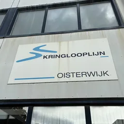 Gevel van kringloopwinkel met wit bord en blauw logo van Kringlooplijn Oisterwijk