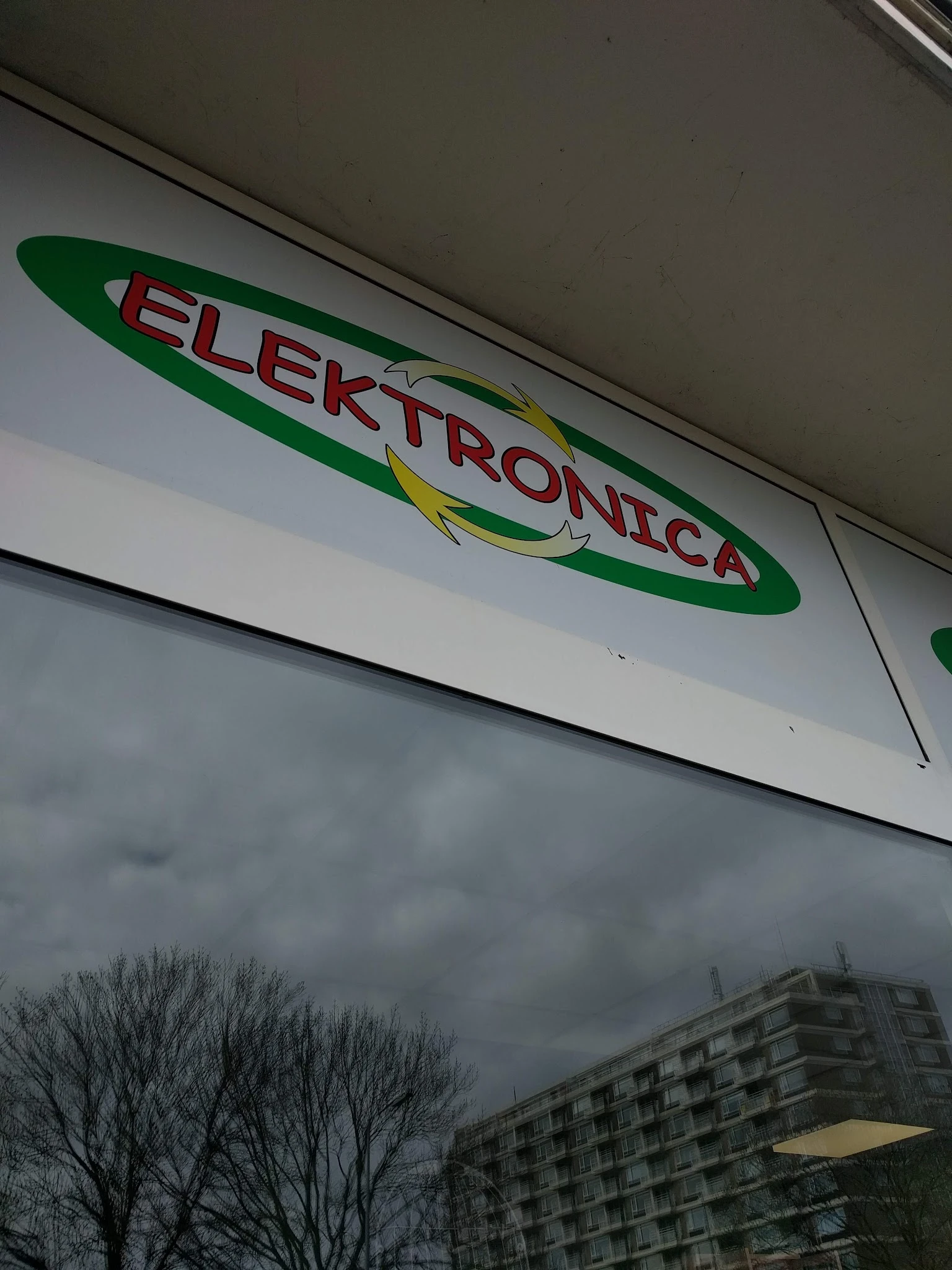 Groen-wit winkelfront met rood logo 'Elektronica' en geel accent