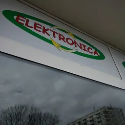 Groen-wit winkelfront met rood logo 'Elektronica' en geel accent